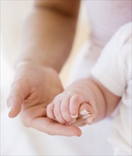 Close up of baby holding mother’s hand. Date : 2008