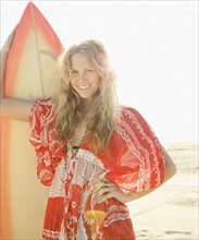 Woman holding surfboard on beach. Date : 2008