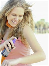 Woman spraying on sunscreen. Date : 2008
