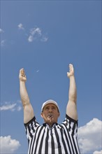 Male football referee making touchdown call.