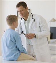 Male doctor examining boy.