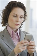Businesswoman looking at electronic organizer.