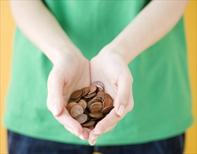 Woman holding handful of pennies. Date : 2008