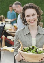Woman holding bowl of salad.
