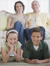 Family with two children watching television.