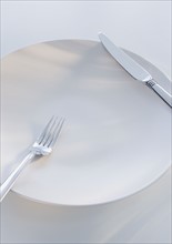 Close up of fork and knife on plate.