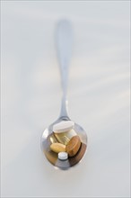 Close up of vitamins on spoon.