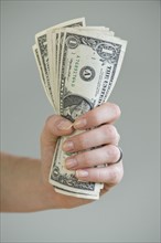 Woman holding handful of money.