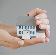Woman holding model house.