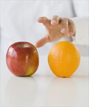 Man reaching for apple and orange.