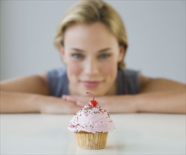 Woman looking at cupcake.