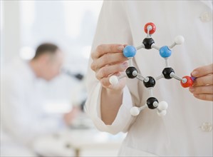 Female scientist holding molecular model.