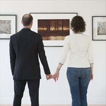 Couple looking at art in art gallery.