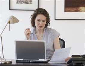 Businesswoman looking at laptop.