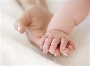 Close up of baby holding mother’s hand. Date : 2008