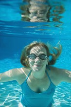 Woman wearing goggles underwater. Date : 2008
