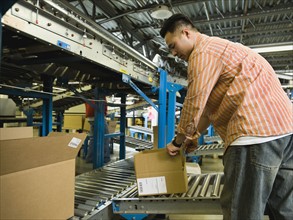 Asian male factory worker checking product. Date : 2008