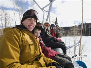 Family sitting on ski lift chair. Date : 2008