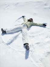 Woman making snow angel. Date : 2008