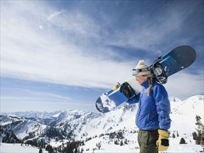 Woman holding snowboard, Wasatch Mountains, Utah, United States. Date : 2008