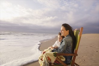 Mother and child sitting in beach chair. Date : 2008