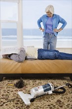 Woman looking at man sleeping next to vacuum. Date : 2008