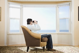 Man looking through binoculars. Date : 2008