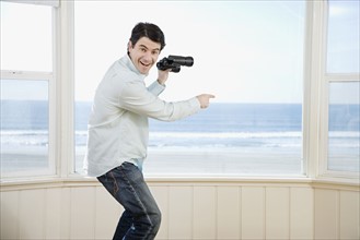 Man pointing and holding binoculars. Date : 2008