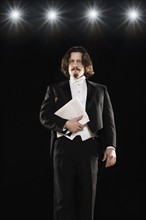 Man in tuxedo holding sheet music. Date : 2008