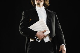 Man in tuxedo holding sheet music. Date : 2008