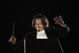 Man conducting behind music stand. Date : 2008