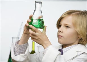 Boy looking at beaker of liquid. Date : 2008