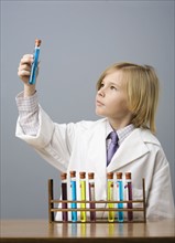 Boy looking at vial of liquid. Date : 2008