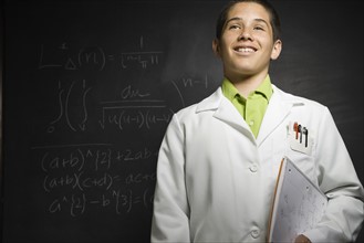 Boy wearing lab coat in front of blackboard . Date : 2008