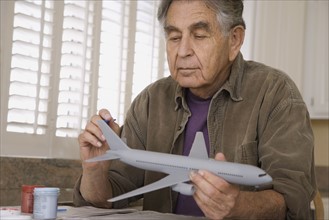 Senior man painting airplane model. Date : 2008