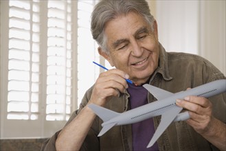 Senior man painting airplane model. Date : 2008