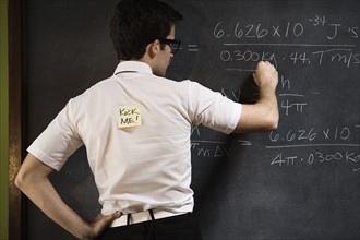 Nerdy man writing on blackboard. Date : 2008