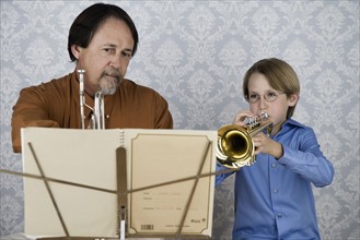 Boy playing trumpet for teacher. Date : 2008