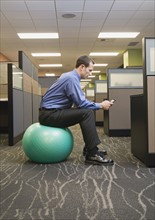 Businessman sitting on exercise ball. Date : 2008