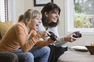 Mother and daughter playing video games. Date : 2008