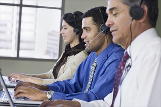 Multi-ethnic businesspeople wearing headsets. Date : 2008