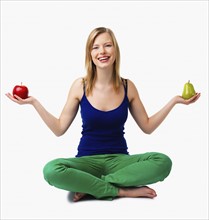 Woman holding apple and pear in hands. Date : 2008