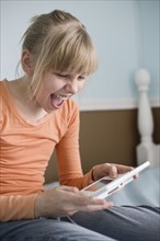 Girl playing handheld video game. Date : 2008