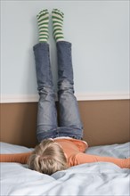 Girl laying on bed with feet on wall. Date : 2008
