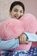 Girl hugging heart pillow. Date : 2008