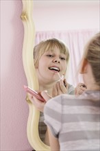 Girl applying lip gloss. Date : 2008