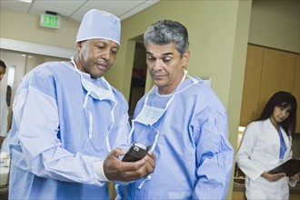 Multi-ethnic doctors looking at equipment. Date : 2008