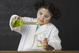 Girl pouring liquid in science class. Date : 2008