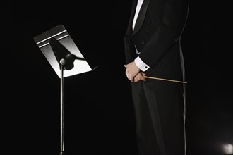 Male conductor standing next to music stand. Date : 2008