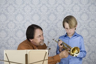 Music teacher teaching boy to play trumpet. Date : 2008
